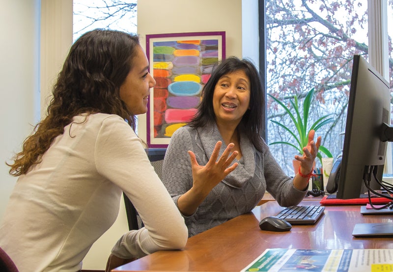 photo of faculty member helping student at a desk