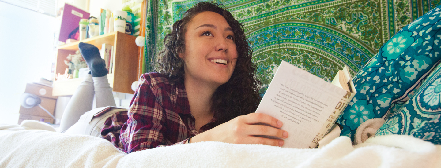 Student reading in a residence hall room