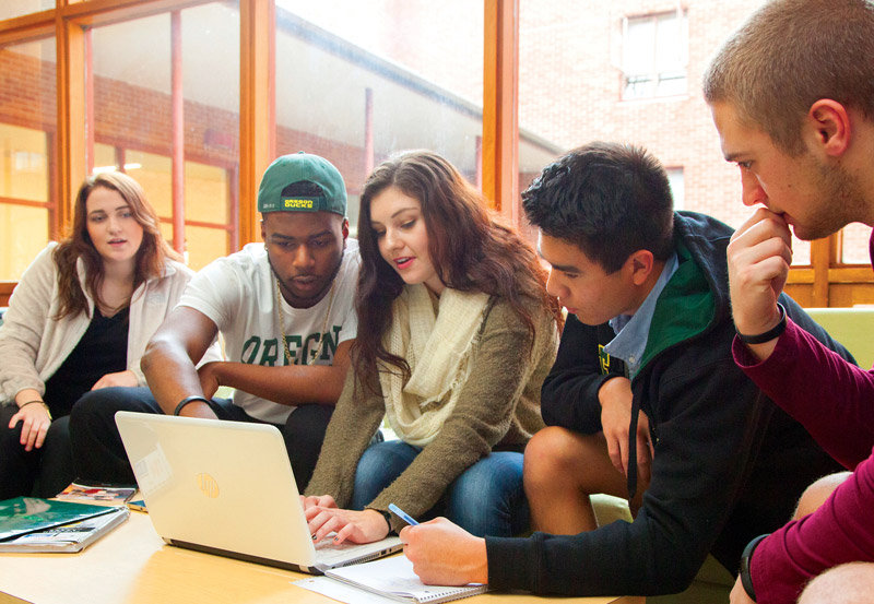 Photo of students gathered around a computer.